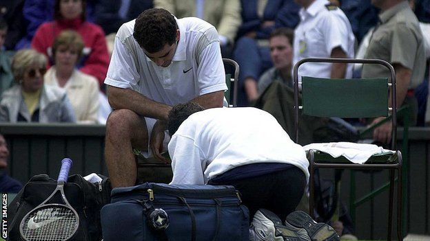 Pete Sampras receiving treatment on his injured shin in his Wimbledon second-round match in 2000