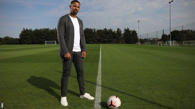 Anton Ferdinand stands on an empty pitch