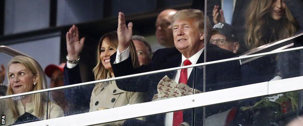 Former US President Donald Trump does the 'tomahawk chop' gesture at Truist Park during game foiur