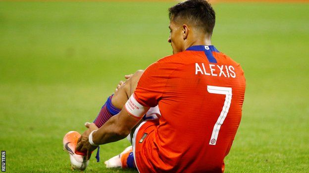 Alexis Sanchez on the ground after injuring his ankle playing for Chile against Colombia