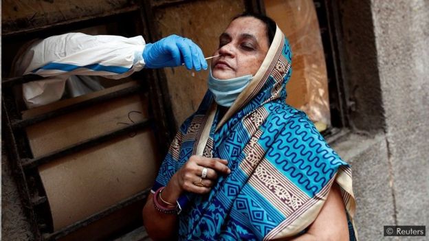 Um trabalhador médico coleta uma amostra para testar o Covid-19 em Nova Déli, na Índia