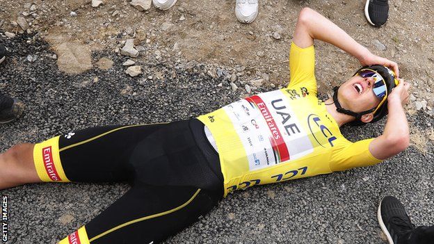 Yellow jersey wearer Tadej Pogacar lies on the floor in exhaustion after winning stage 17 of the 2021 Tour de France