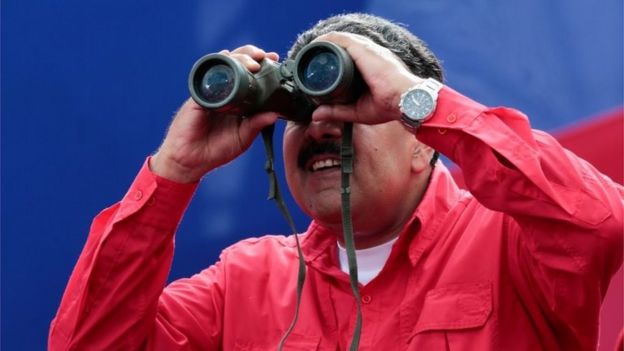 Venezuela's President Nicolas Maduro uses binoculars during a rally in Caracas, Venezuela April 19, 2017.