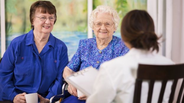 Mujeres mayores con doctora en casa para ancianos.