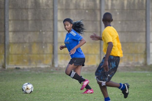 Une fille et un garçon sur un terrain de football.