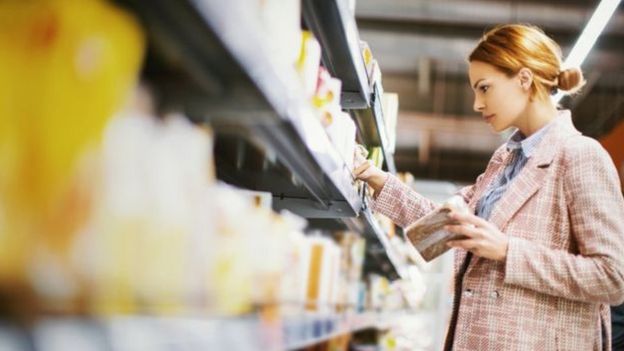 Mulher escolhendo produtos em prateleira