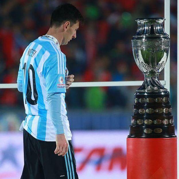 Lionel Mess pasa por al lado del trofeo de la Copa América.