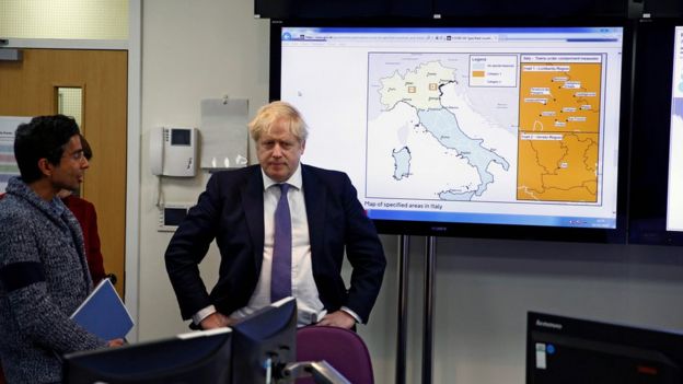 Britain"s Prime Minister Boris Johnson reacts in front of a map of Italy in the command centre during a visit to the Public Health England National Infection Service in Colindale in north London