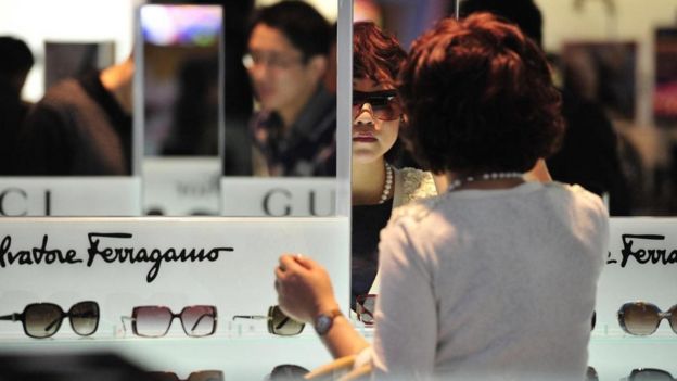 Mulher experimenta óculos em loja de aeroporto