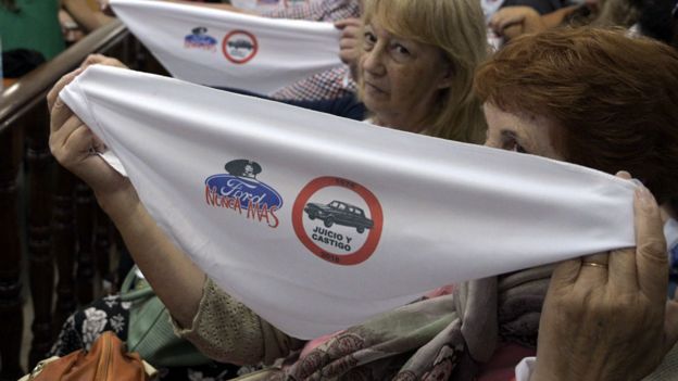 Durante el juicio, las víctimas y sus familiares mostraron los tradicionales pañuelos blancos de las Madres de Plaza de Mayo con insignias contra Ford.