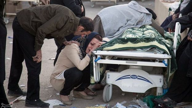 A woman reacts next to a dead body following an earthquake in Sarpol-e Zahab county in Kermanshah, Iran November 13, 2017