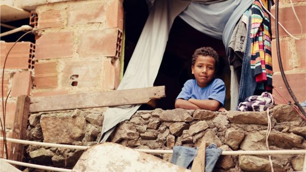 Menino em uma casa de favela