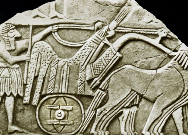Una de las primeras representaciones conocidas de la rueda, en un bajorrelieve de un carro. Es una de las muchas esculturas en sarcófagos descubiertas en 1928 en las Tumbas Reales de Ur en la antigua Mesopotamia (ahora Irak).