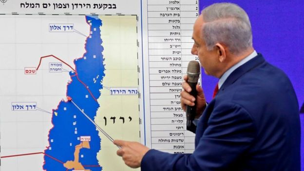 Netanyahu fala ao microfone mostrando mapa