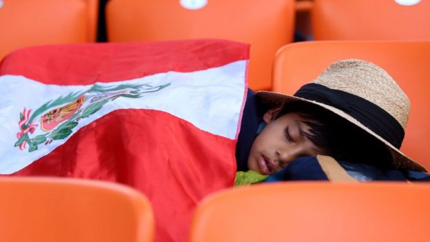 Un niño duerme en un estadio.