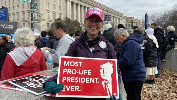 Sarah Schultz holds sign reading 'most pro-life president ever'