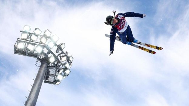 Un hombre dando con un salto con esquís.