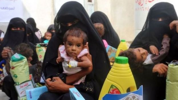 نساء يحملن أطفالهن في اليمن