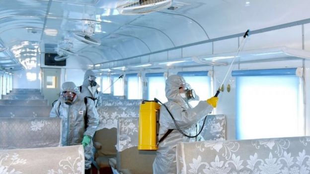People in protective suits spraying disinfectant at an undisclosed location in North Korea