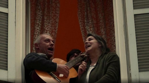 Pessoas cantando de janelas na Itália