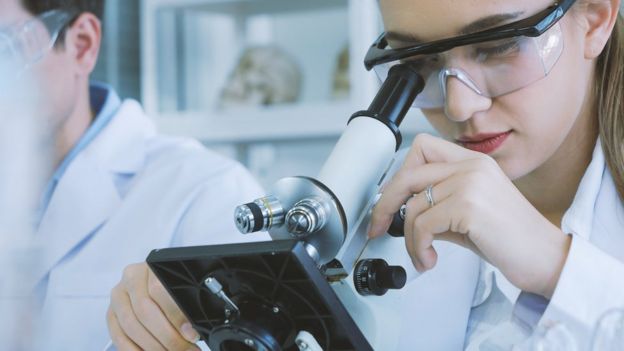 Muchacha en el microscopio