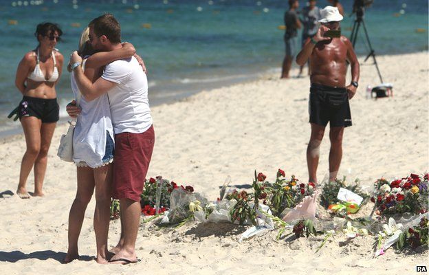 Tourists pay their respects to victims of the gun attack in Sousse, Tunisia