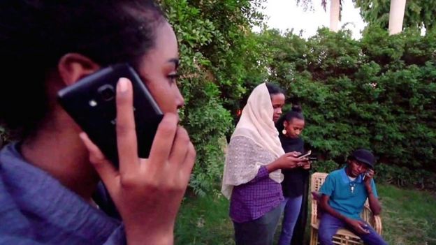 Manifestantes con celulares en Sudán