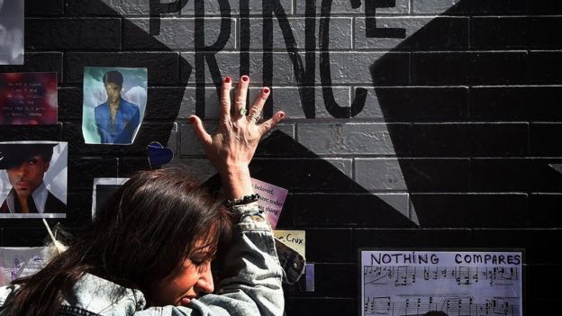 Prince fan touches the star of music legend Prince who died suddenly at the age of 57