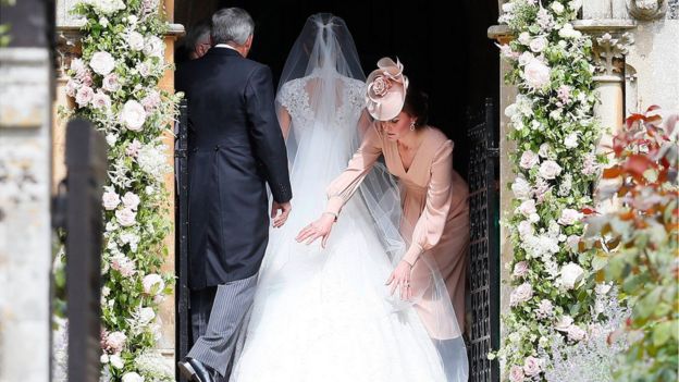The Duchess of Cambridge adjusting Pippa Middleton's dress