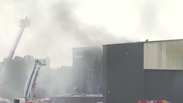 Smoke billowing from a hangar where a plane crashed