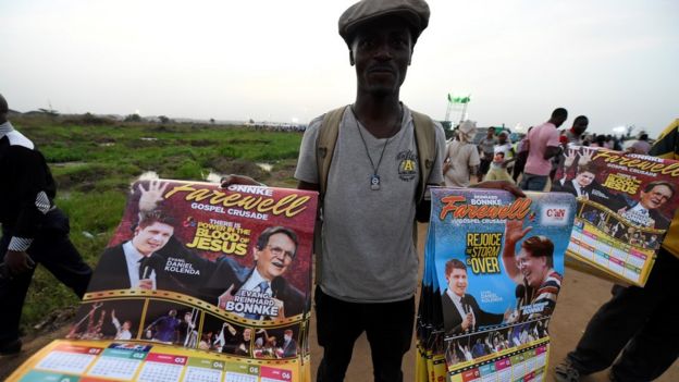 Un marchand vend des affiches avec des photos de l'évangéliste pentecôtiste allemand Reinhard Bonnke et de son successeur Daniel Kolenda avant la "croisade d'adieu" de Reinhard Bonnke, le 9 novembre 2017 à Lagos.