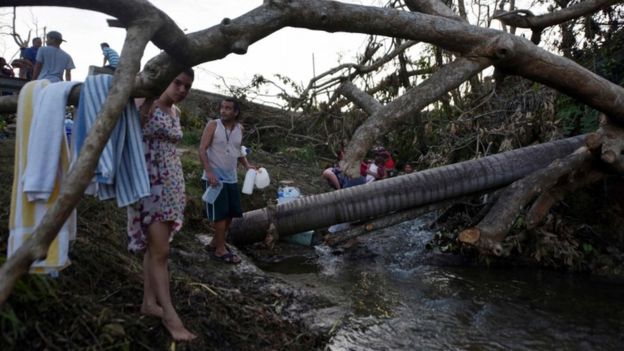 Una familia se abastece de agua en una quebrada