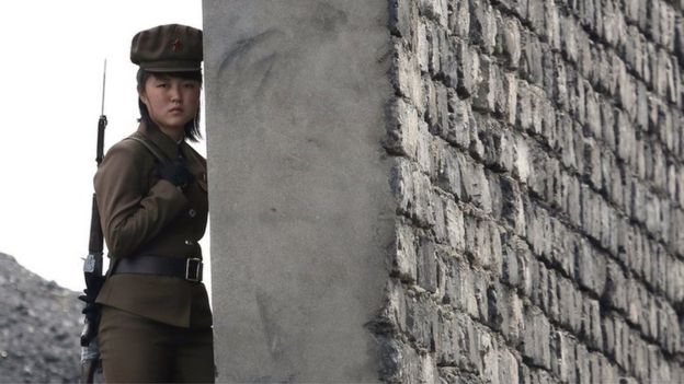 A North Korea woman soldier patrols the bank of the Yalu River which separates the North Korean town of Sinuiju from the Chinese border town of Dandong