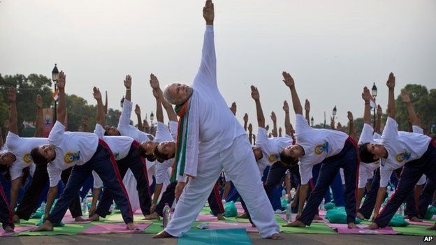 Indian Prime Minister Narednra Modi performs yoga along with thousands of Indians on Rajpath, in New Delhi, India, Sunday, June 21, 2015.