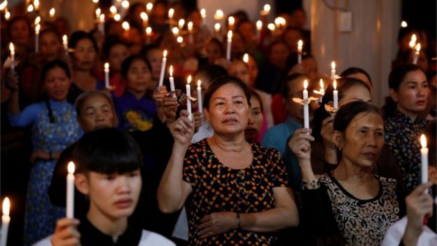 mujeres rezan con velas