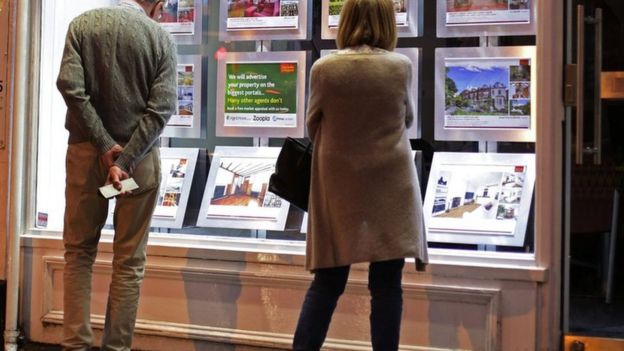 Couple looking in estate agent window