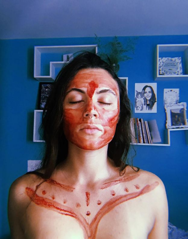 Laura, médica de 27 anos com o rosto e parte do colo coberto com sangue de menstruação