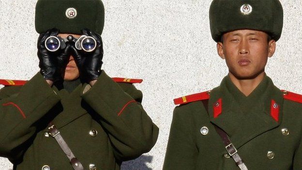North Korean soldiers peer across the Demilitarized Zone into South Korea.