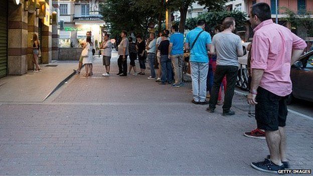 Greeks queue for cash outside an ATM in Thessaloniki