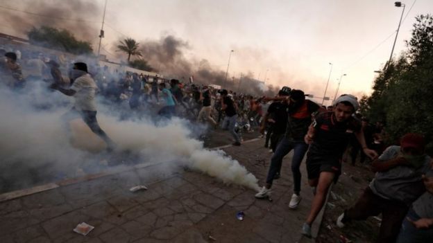 Protesters run away after security forces use tear gas in Baghdad, Iraq. Photo: 5 October 2019