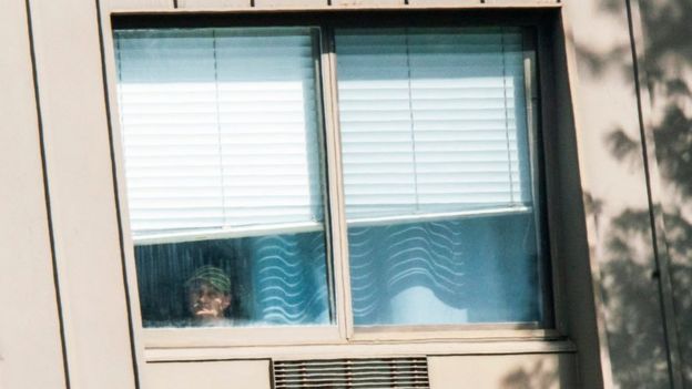 Man looks out window of facility