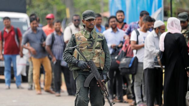 Sri Lankan army personnel stand guard at a checkpoint as they search people and their bags at a check point in Kattankudy near Batticaloa, Sri Lanka, 28 April