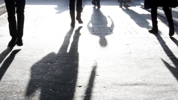 Sombras de personas en el pavimento