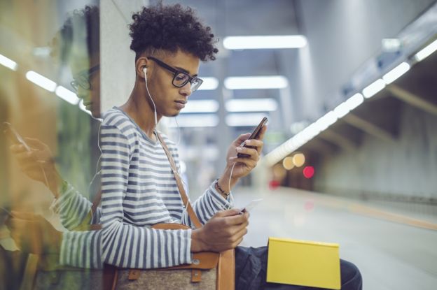 A young man listening to his headphones during the commute