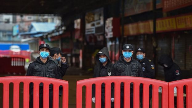 Policías afuera del mercado de Huanan en Wuhan.