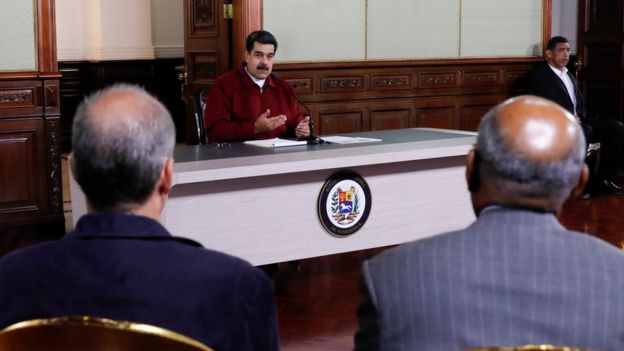 Nicolás Maduro fala em reunião observado por outras pessoas no Palácio Miraflores