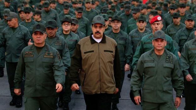 This handout picture released by Miraflores Palace press office shows Venezuela's President Nicolas Maduro waving military troops accompanied by Defense Minister Vladimir Padrino (L) at the "Fuerte Tiuna" in Caracas, Venezuela on May 2, 2019