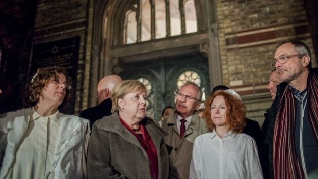 German Chancellor Angela Merkel (C) talks to Rabbi Gesa Ederberg (L) and other members of the Jewish community at a vigil outside the New Synagogue in Berlin
