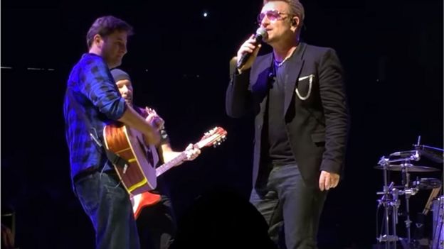 Harry Kantas on stage with U2