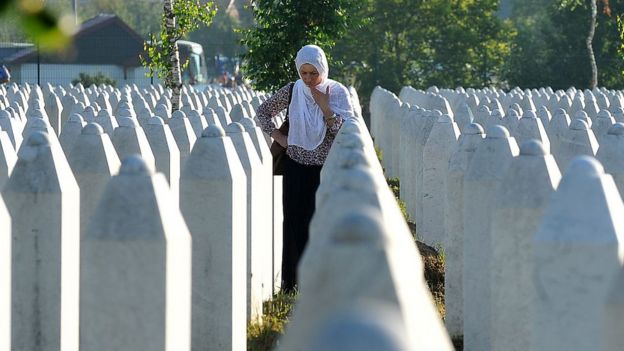 A Bosnian Muslim woman, survivor of Srebrenica 1995 massacre, mourns near graves of her relatives, at the memorial cemetery in the village of Potocari, near Eastern-Bosnian town of Srebrenica